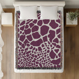 Zuma Animal Print Cotton Blend Blanket Throw in Purple, on a bed