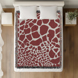 Zuma Animal Print Cotton Blend Blanket Throw in Red, on a bed